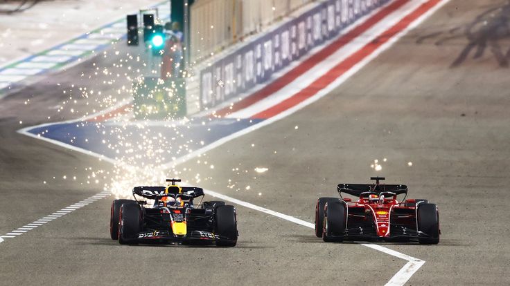 two red bull racing cars driving down a race track with fireworks coming out of their tires