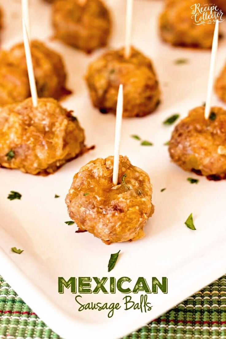 some meatballs are sitting on a white plate with toothpicks in the middle