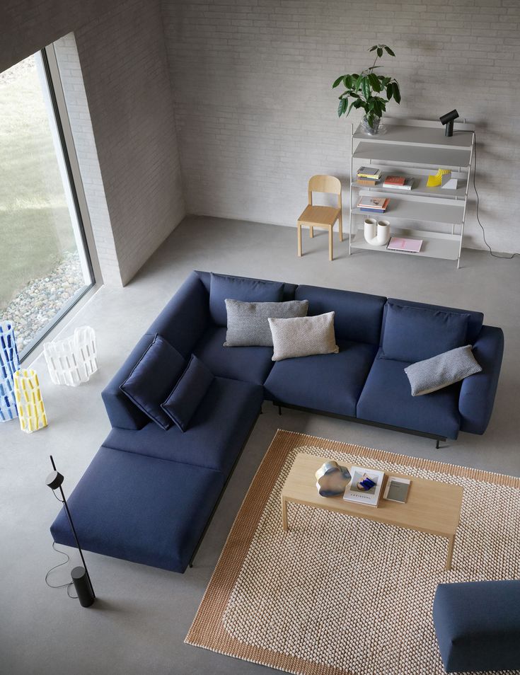 a living room with blue couches and pillows on the floor next to a coffee table