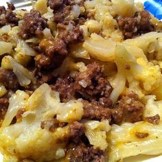 a close up of a plate of food with meat and cheese on it, including noodles