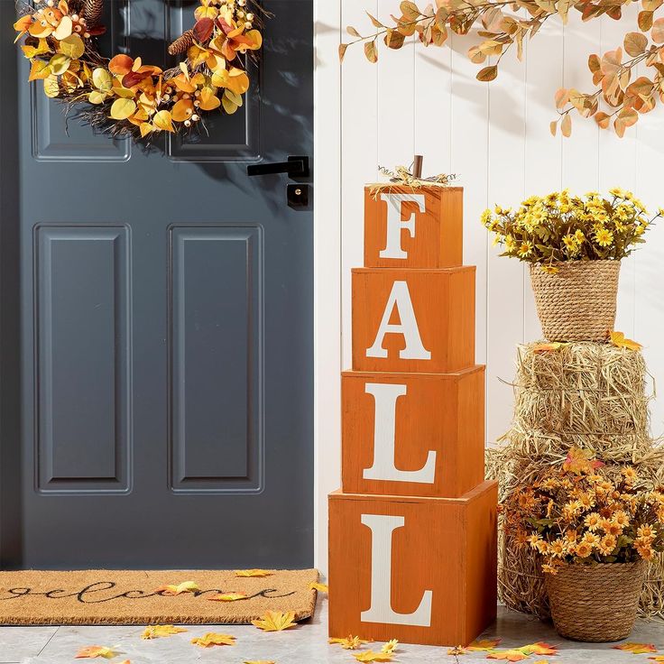 fall decorations on the front porch with pumpkins and hay bales stacked up next to it