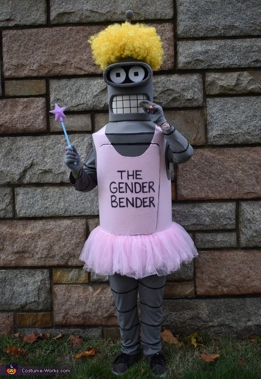 a person in a costume that says the genderer bender is standing next to a brick wall