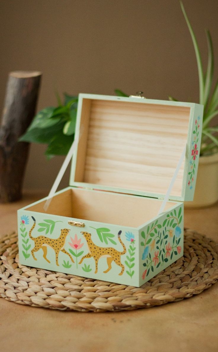 an open box sitting on top of a wicker table next to a potted plant