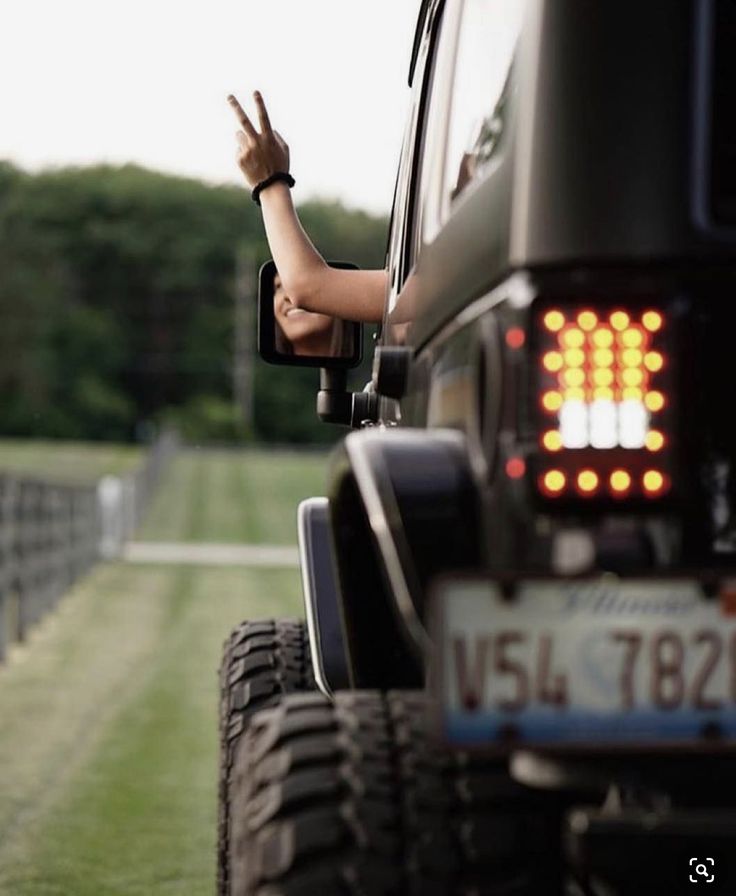 a person waving from the back of a truck