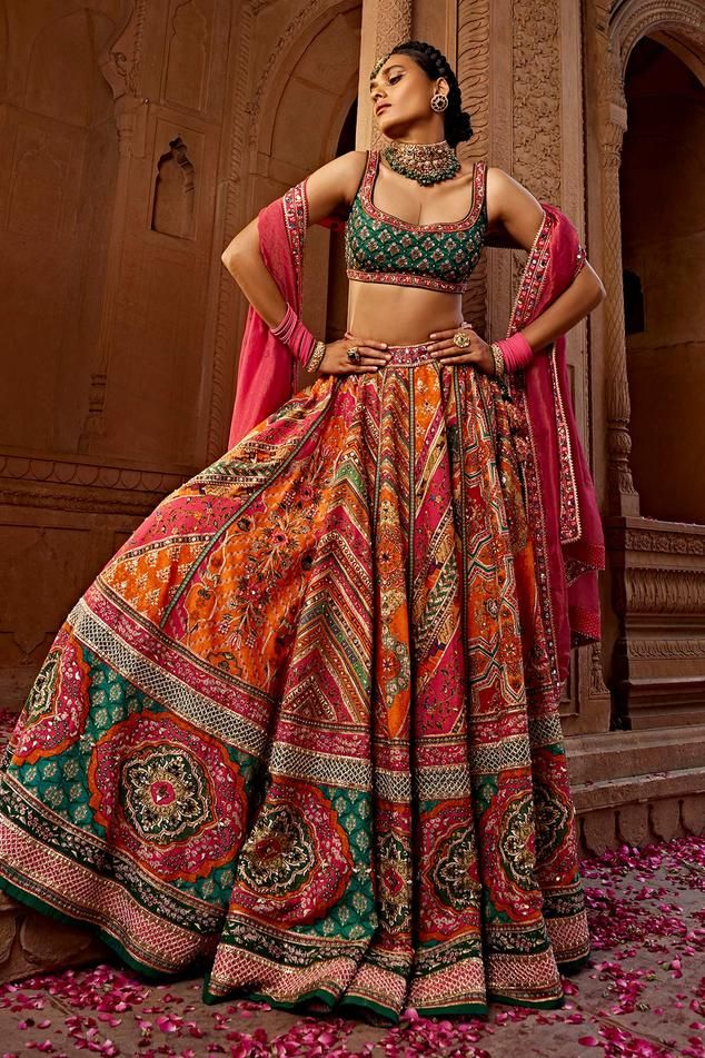 Orange, pink and green attached cancan lehenga with all over floral, mandala print, accentuated with heavy tassel strings with gota embroidery, hand adda work, beads and sequins embellishments. Paired with a padded blouse with all over quatrefoil print and sequin embellishments. Comes along with a dupatta with floral embroidered border.
Components: 3
Pattern: Print, Embroidery
Type Of Work: Floral, Mandala, Sequins, Beads
Neckline: Scoop Neck
Sleeve Type: Sleeveless
Fabric: Blouse and Lehenga: R A Line Lehenga, Choli Dress, Lehenga Dupatta, Anamika Khanna, Diana Penty, Lehenga Choli Online, Multi Color Blouse, Sonakshi Sinha, Wedding Saree Indian