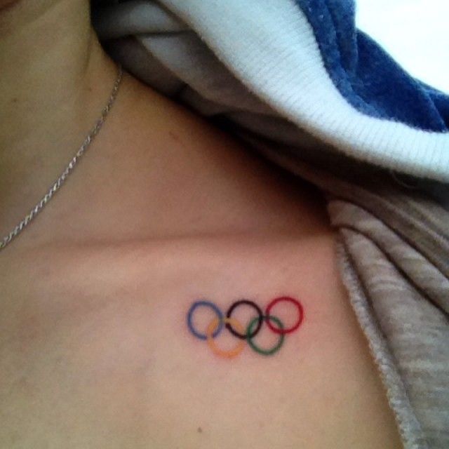 a woman's chest with an olympic symbol tattoo on it