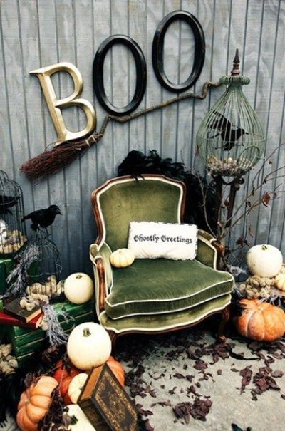 an old chair and some pumpkins in front of a sign that says boo on it