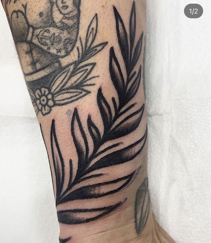 a person with a tattoo on their arm that has leaves and an angel in the background