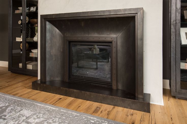 a fire place in a living room next to a book shelf