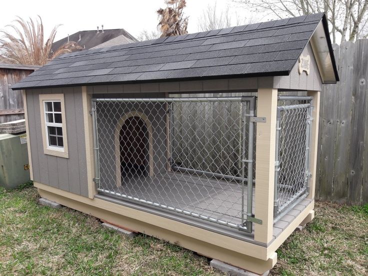 a dog house with a fence around it and a door on the side that is open