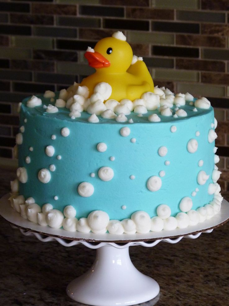 a blue cake with white frosting and a rubber duck on top