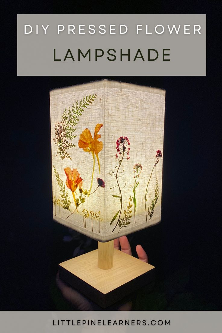 a lamp that has flowers on it with the words diy pressed flower lampshade