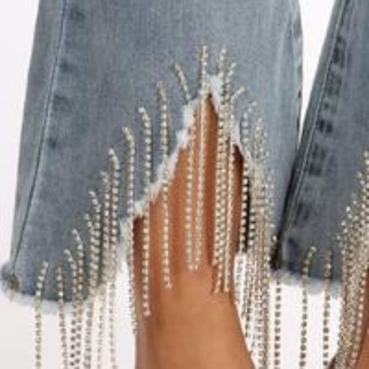 a woman's legs in ripped jeans with chains on them