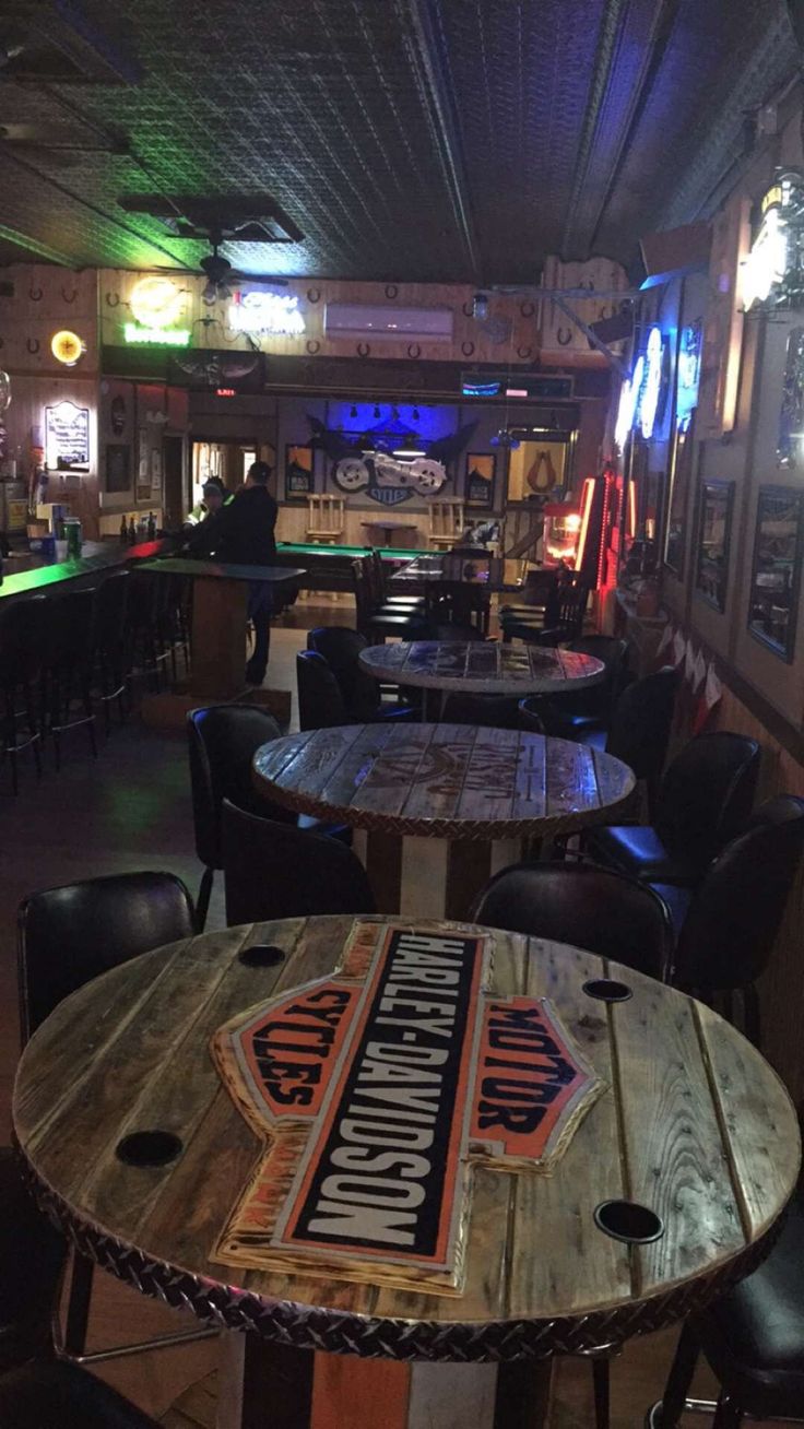 the inside of a bar with several tables and chairs