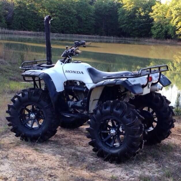 a white four wheeler parked next to a body of water