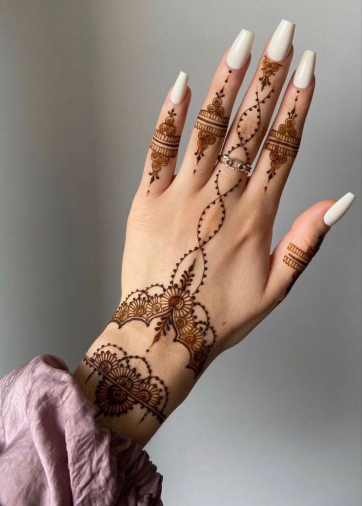 a woman's hand with henna tattoos on it