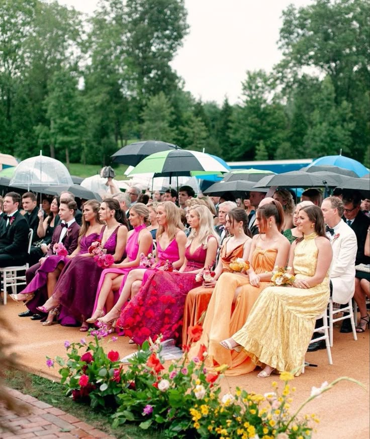 a group of people sitting next to each other under umbrellas