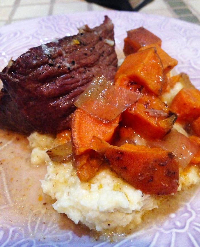 steak, mashed potatoes and carrots are on a plate with gravy