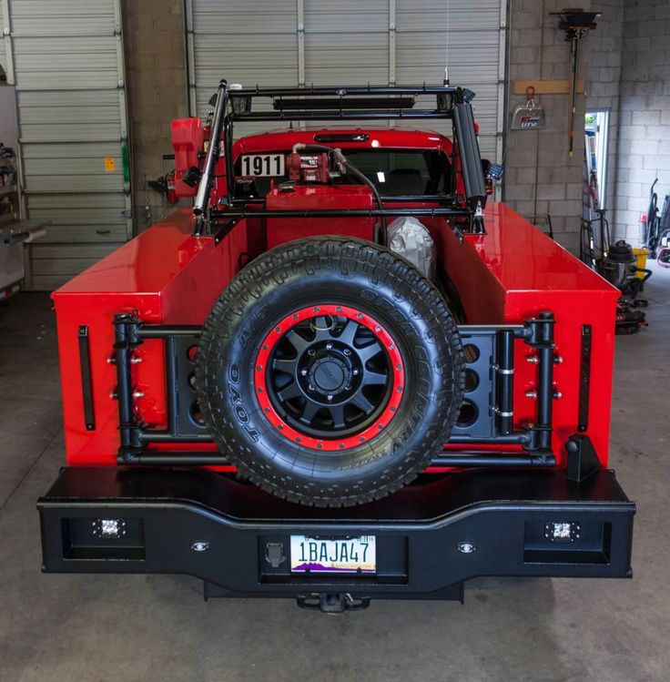 a red jeep is parked in a garage