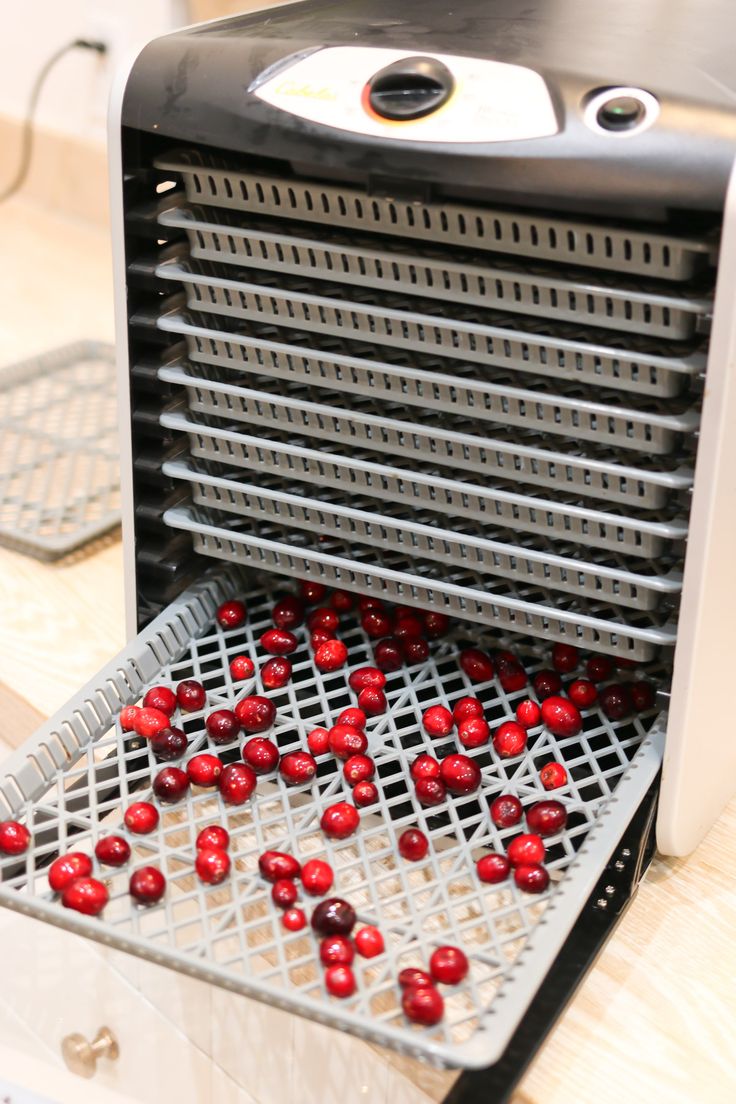 a close up of a machine with red balls coming out of it's tray