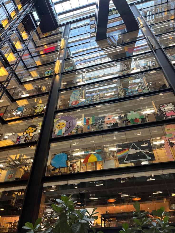 the inside of an office building with lots of windows and plants in front of it