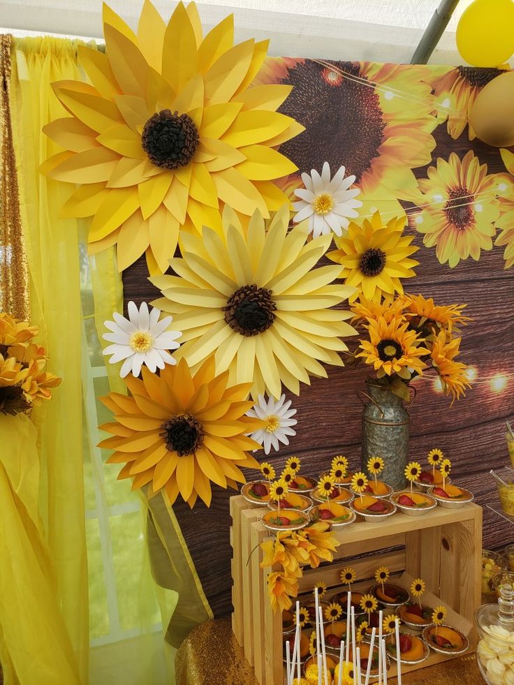 a table with sunflowers on it and candy bars in front of the wall