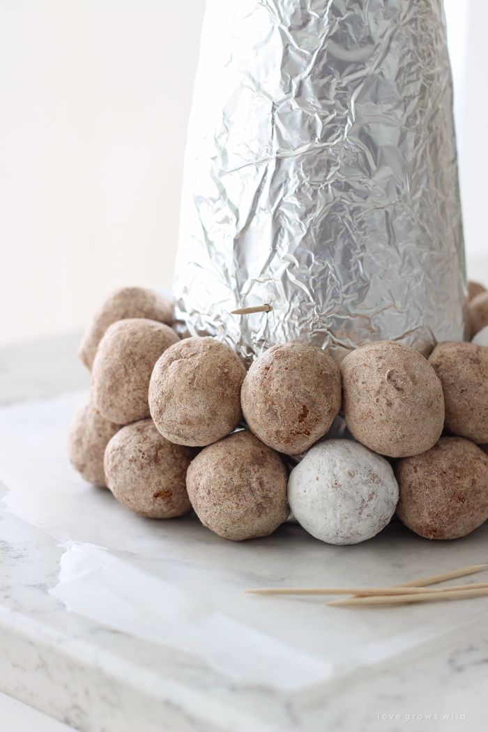 there are some balls on the table next to a silver tinfoil cone with sticks sticking out of it