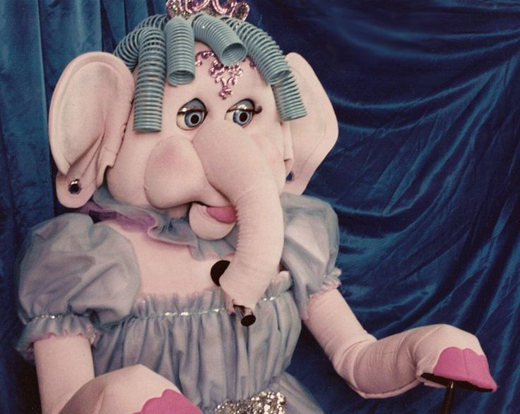 an elephant dressed as a princess sitting on top of a chair