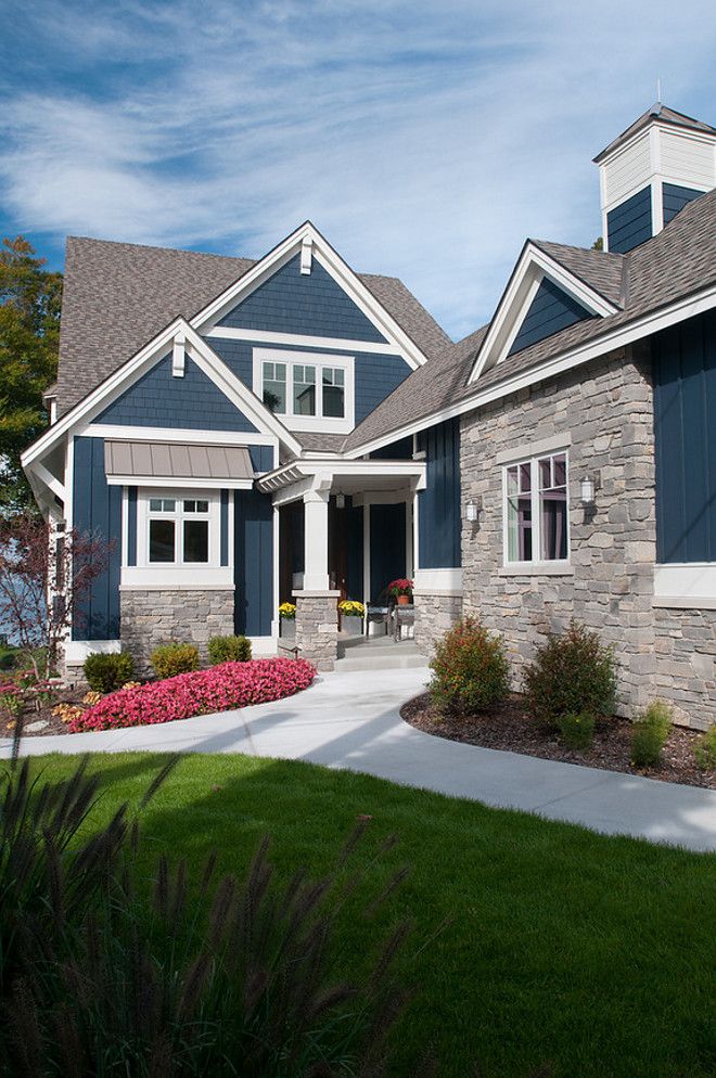 a large house with blue shutters and white trim on the front door is shown