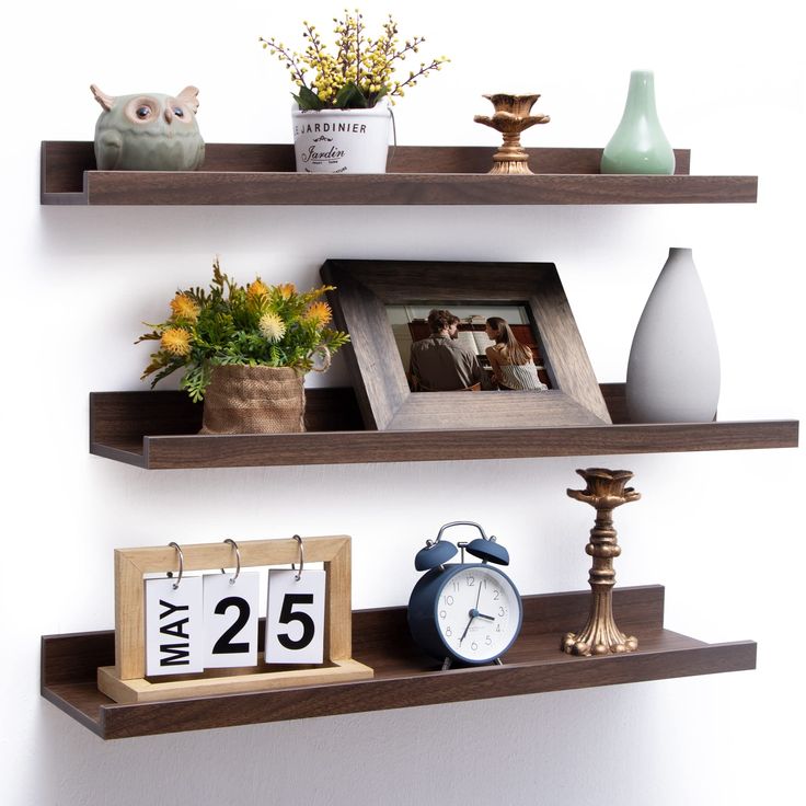 two shelves with pictures, flowers and an alarm clock on them are displaying the time