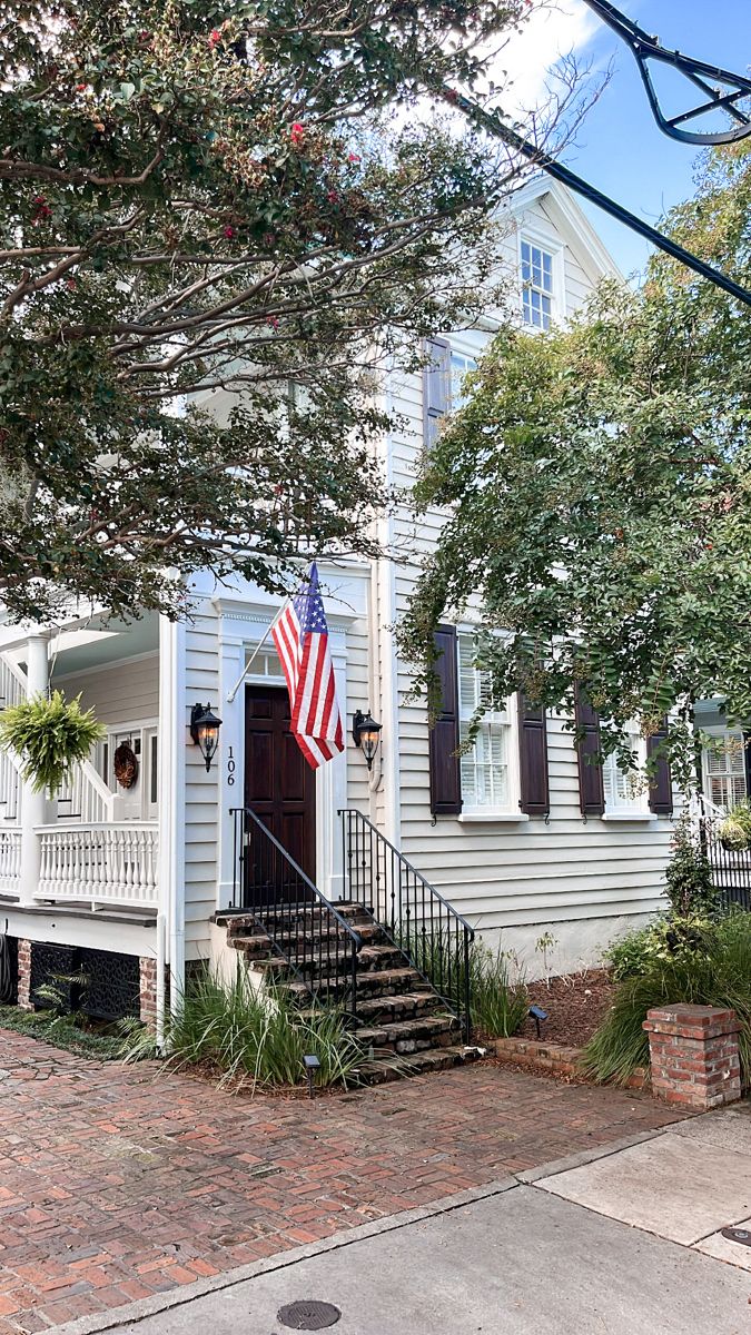 a white house with an american flag on the front porch