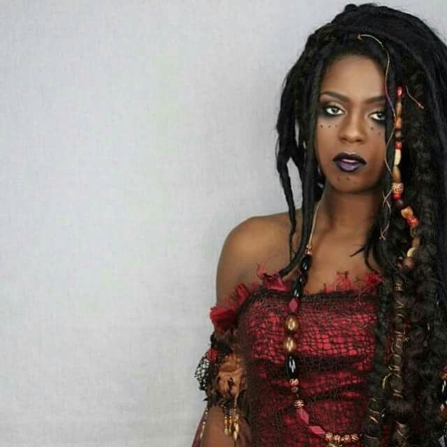 a woman with dreadlocks wearing a red dress