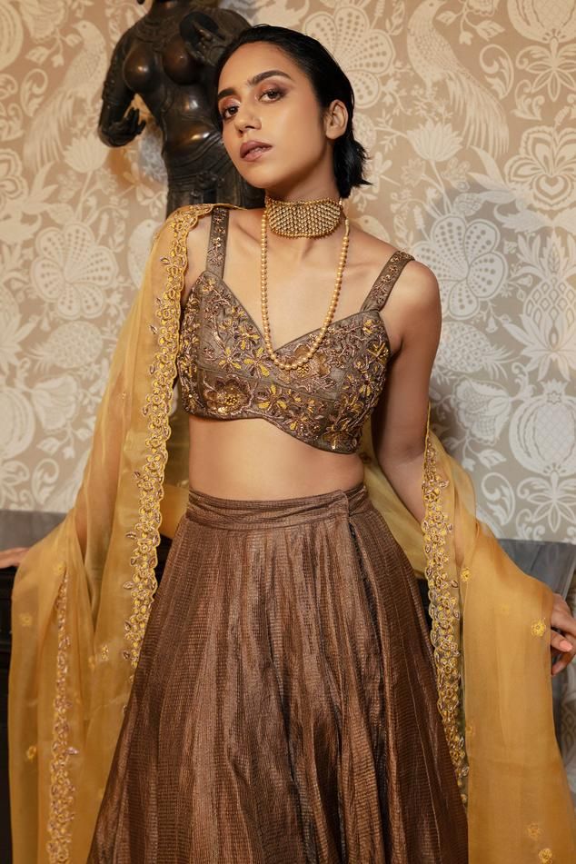 Brown flared lehenga with attached cancan. Comes with saadi, french knots and antique sequins floral embroidered padded blouse and mustard floral scallop border dupatta.
Components: 3
Pattern: Embroidery
Type Of Work: Floral
Neckline: Sweetheart neck
Sleeve Type: Sleeveless
Fabric: Blouse and Skirt: Tissue, Silk Organza
Dupatta : Silk Organza 
Color: Brown, Yellow
Other Details: 
Model height: 5 ft 7 inches, wearing size S
Lehenga:
Attached cancan
Length: 45 inches
Blouse:
Padded
Inverted V hem Flared Lehenga, Brown Flares, Scallop Border, Padded Blouse, Brown Blouse, French Knots, Embroidery Floral, Pattern Embroidery, Organza Dupatta