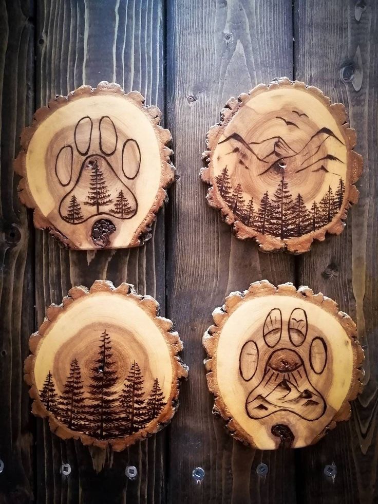 three wood slices with trees and mountains on them