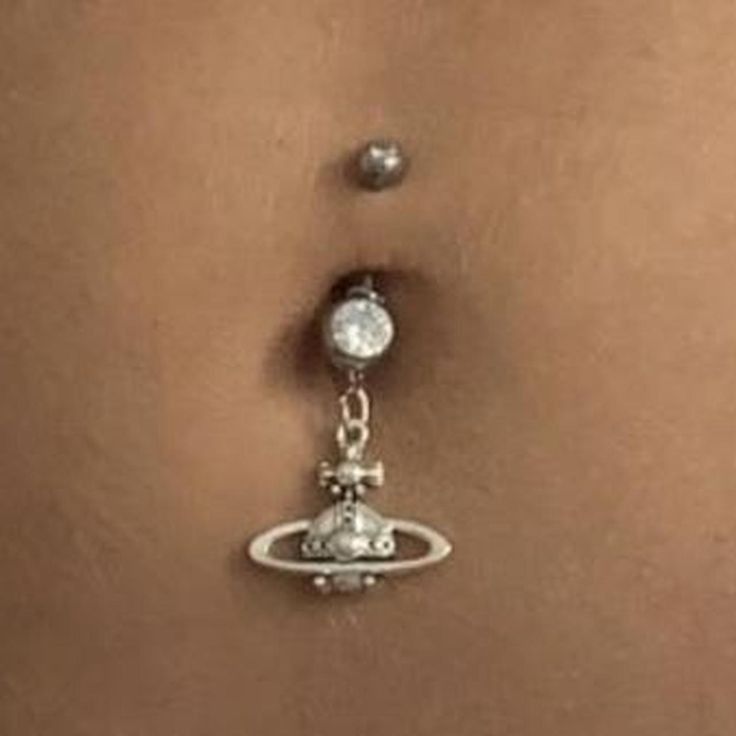 the belly button is attached to a chain with pearls and beads on it's side