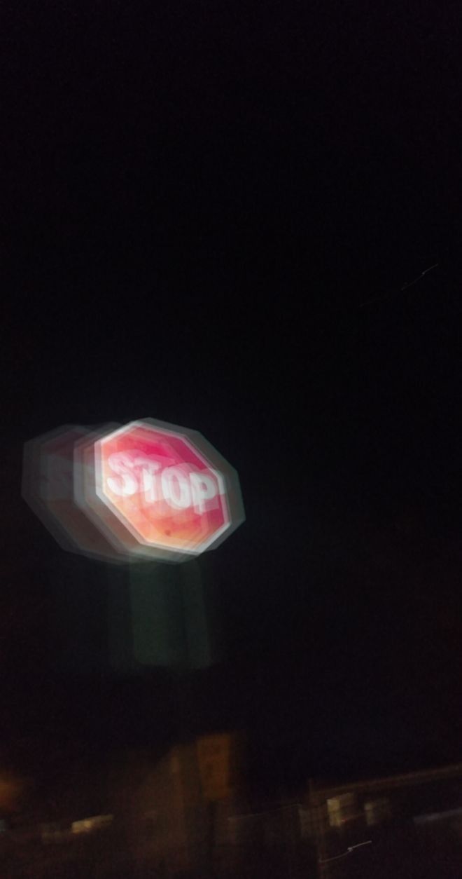 a stop sign is lit up at night