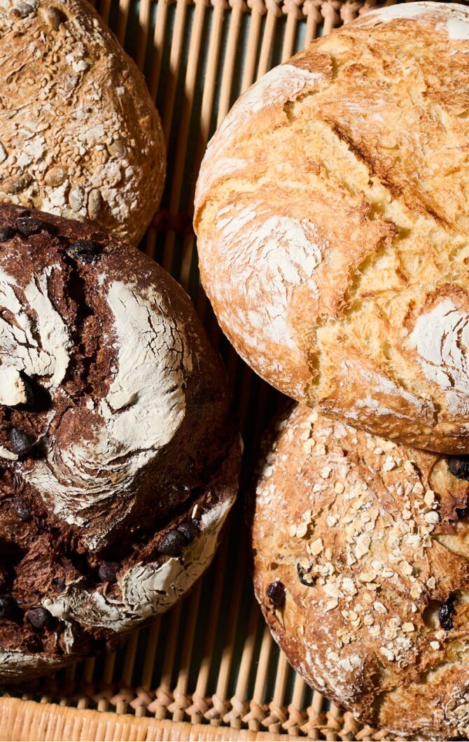 three loaves of bread sitting in a wicker basket