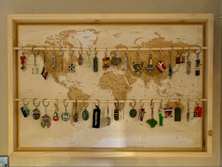 a world map with many key chains hanging from it's sides and on the wall