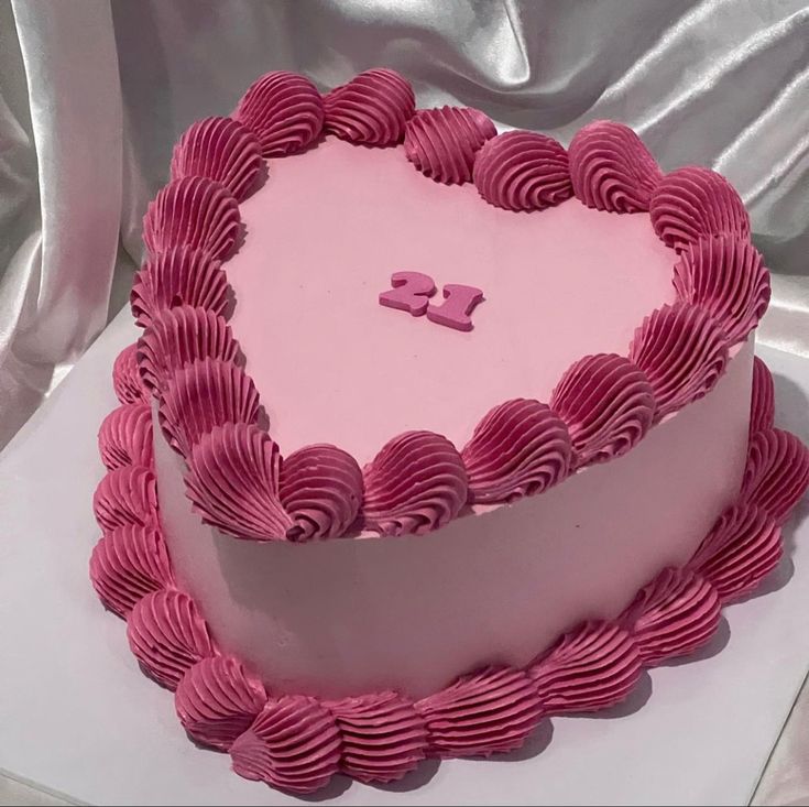 a heart shaped cake with pink icing on it