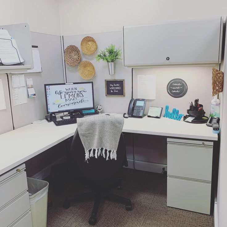 an office cubicle with a desk, computer and file cabinet in it's corner