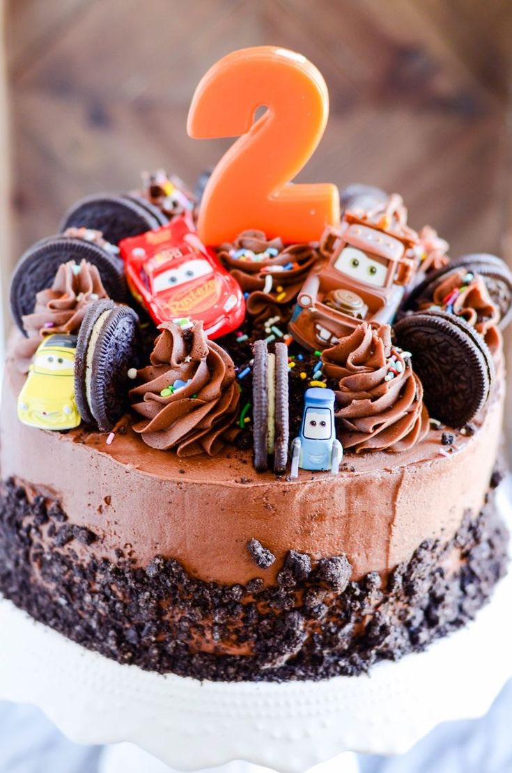 a birthday cake with cars on it and the number two in the middle is chocolate frosting