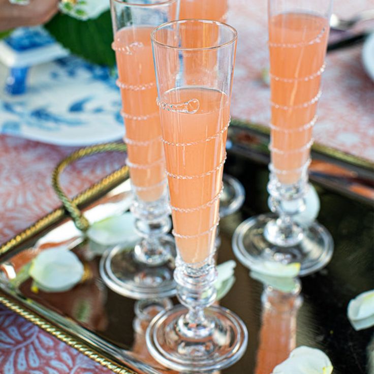 three champagne flutes sitting on top of a tray