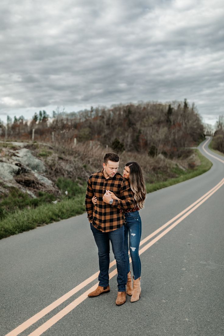 a man and woman standing on the side of a road