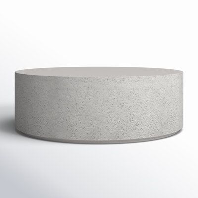 a round concrete table sitting on top of a white floor