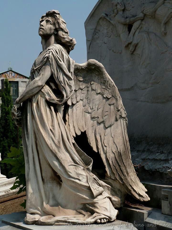 an angel statue sitting in front of a building