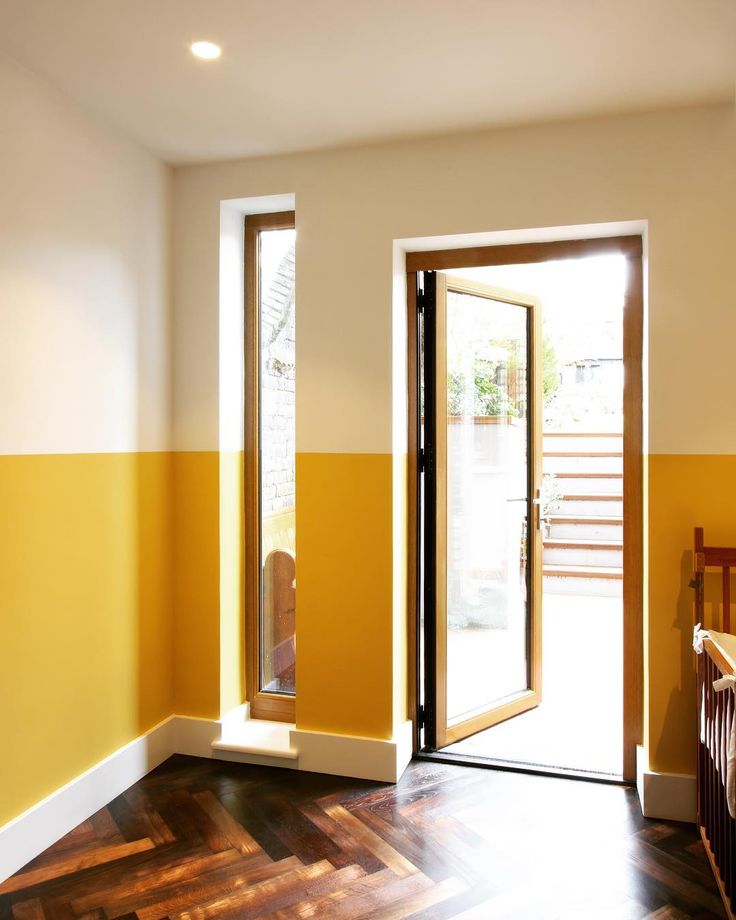 an empty room with wooden floors and yellow walls