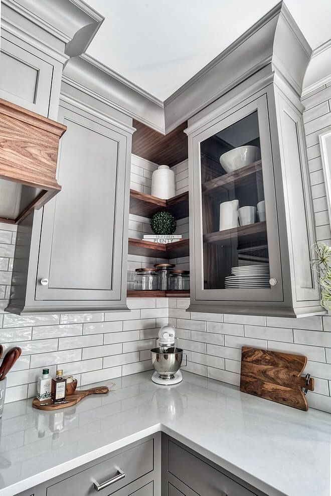 a kitchen with gray cabinets and white counter tops