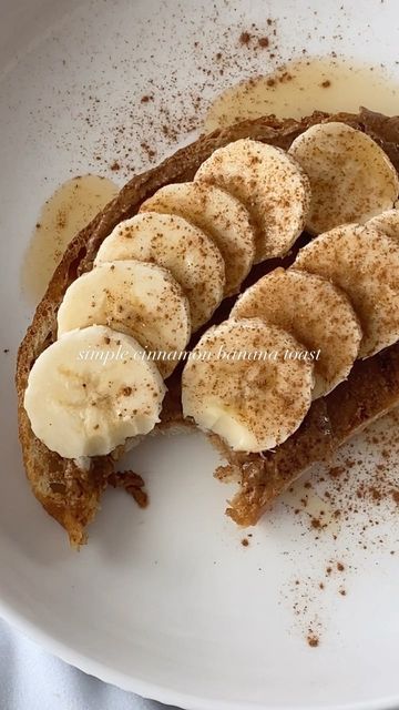 a white plate topped with slices of bread covered in banana slices and powdered sugar