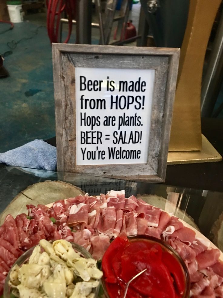 a platter of meats and vegetables with a sign saying beer is made from hops