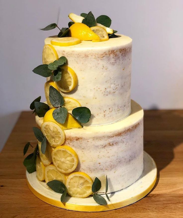 a three tiered cake with lemon slices and leaves